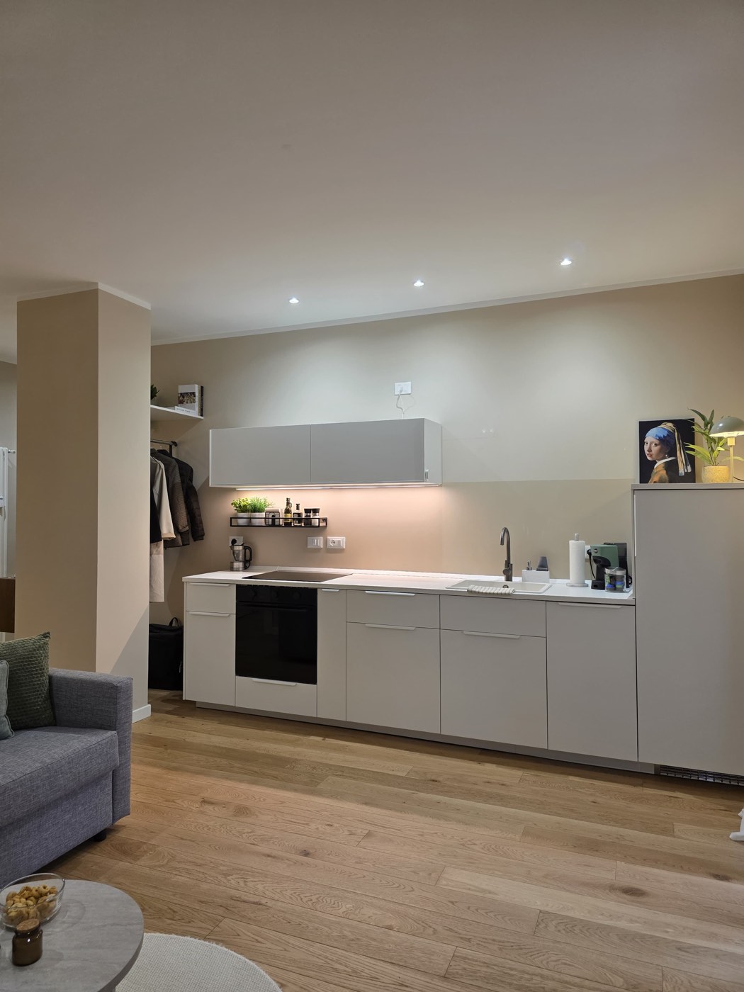 Cucina con mobili bianchi, piano cottura e forno